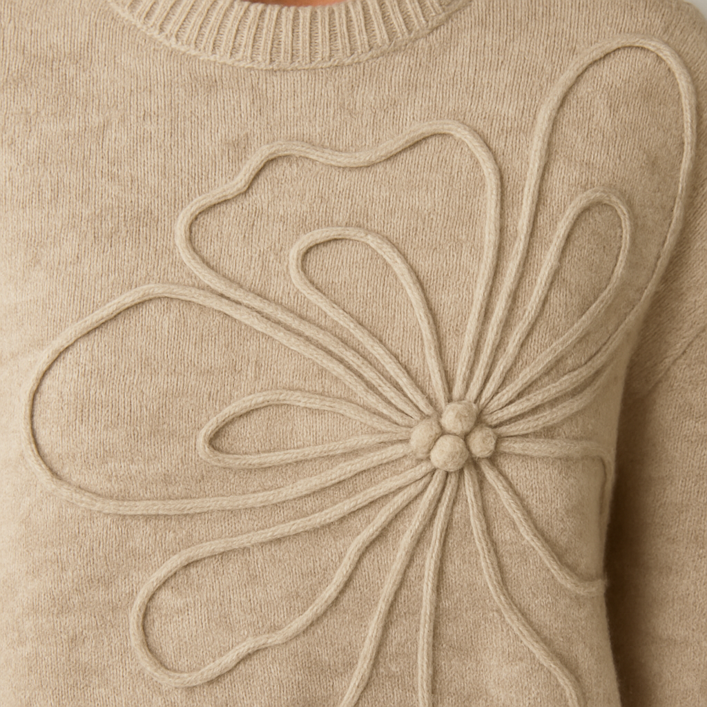 Beigefarbener Strickpullover mit großem eingearbeitetem Blumen-Relief und langen Ärmeln.
